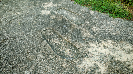 Permanent Footprints Embossed in Aged Concrete: Abstract Concept of Historical Mark, Legacy, and Lasting Impression
