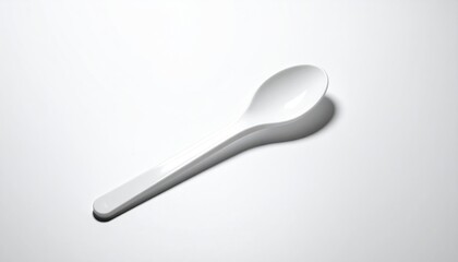 Simple white plastic spoon on a white surface
