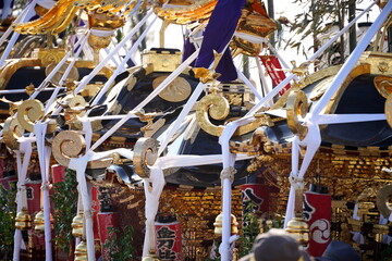 金色に輝く装飾が施された複数の神輿の屋根部分をクローズアップで捉えた日本の伝統的な祭りの様子です