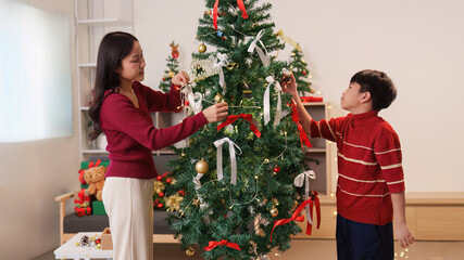 SSTK Christmas. A mother and son decorating a Christmas tree together with joy.