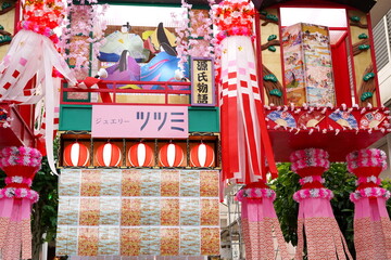 『源氏物語』をテーマにしたと思われる豪華絢爛で立体的な七夕飾りが飾られた賑やかな夏の商店街の様子です