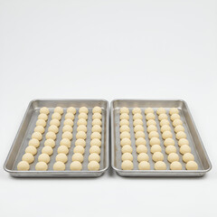 Raw Cookie Dough Balls Lined Up on Two Metal Baking Trays