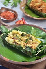 Grilled rice with basil chicken, wrapped in banana leaves, a traditional Indonesian dish