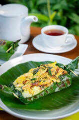 Grilled rice with basil chicken, wrapped in banana leaves, a traditional Indonesian dish