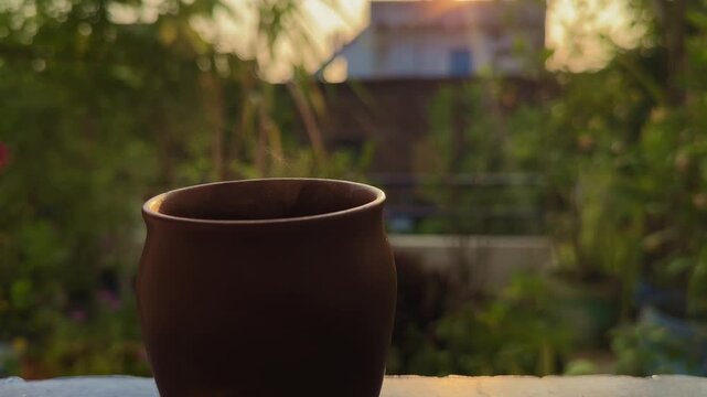 A steaming cup of tea in a clay kullad glows softly in the golden morning light &mdash; capturing the warmth, aroma, and simplicity of traditional Indian tea culture.