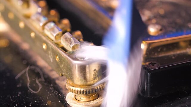 4K Close up shot of a small brush sweeping dust off an electric guitar’s body and strings, revealing texture, shine, and the delicate touch of careful maintenance