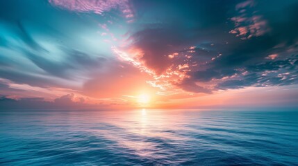 Obraz premium Serene sunset over calm ocean with a vibrant sky and clouds.