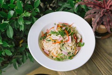 A close-up shot of a delicious pasta dish, beautifully presented in a white bowl with colorful vegetables.