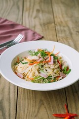 A delicious gourmet dish served on a rustic wooden table, artfully presented, inviting culinary delight. The meal has a beautiful composition of food and colors, enhancing the dining experience