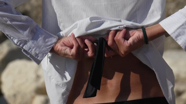 Woman untying swimsuit strings from behind on a sunny beach day
