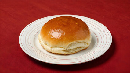 Freshly Baked Golden Bread Roll on a White Plate Soft, Fluffy, and Appetizing for Any Meal