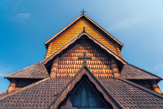 Heddal Stave Church in Telemark with wooden roof under blue sky