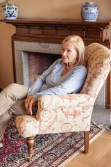 Obraz premium Pensive senior woman sitting in solitude in stylish interior, loneliness concept