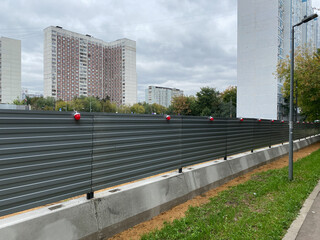 Construction Fence with red markers and concrete base. Site Fence. Hoarding. Construction perimeter.