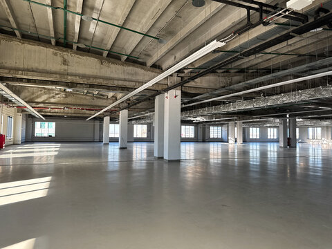 Empty unit. Spacious, modern industrial warehouse interior with columns and concrete floor. Vacant production facility
