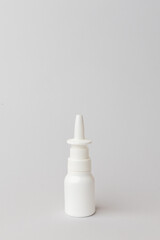 Nasal spray bottle with a sleek design, standing upright on a minimalistic background, representing health and wellness solutions for congestion relief. copy space. Vertical