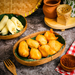 Crispy fried banana with golden batter, a sweet Indonesian snack served hot. Perfect for dessert menus, street food themes, or tropical food photography.