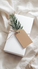 Minimalist Gift Box with Kraft Tag and Evergreen Twig on Cozy Fabric