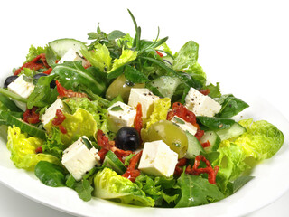 Fresh Mixed green Salad with Feta Cheese and dried Tomatoes isolated on white Background