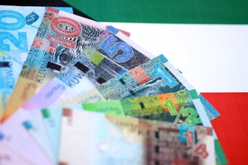 Kuwaiti dinar currency money bills lies on flag close up. The concept of business and investment
