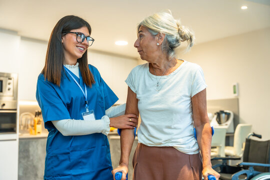 Caregiver assisting senior woman with crutches in home