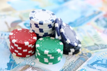 Bahraini dinar currency money bills and bunch of casino chips close up. The concept of gambling and casino games