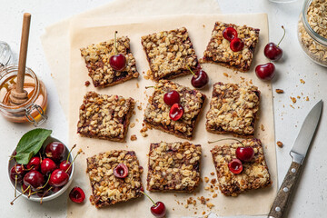Cherry oatmeal crumble bars. Backed cherry crisp. Quick and easy homemade sweet red berry squares with streusel. Crumble fruit cake or pie. Wholesome and healthy breakfast. Home cooking. Top view.