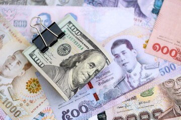 Thai baht currency money bills and bunch of us dollar banknotes close up. The concept of economics and currency exchange