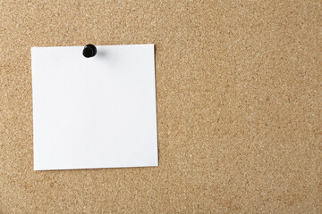 Blank note pinned on cork board, space for text