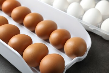 Raw chicken eggs on grey table, closeup