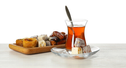 Traditional Turkish tea and desserts on wooden table against white background
