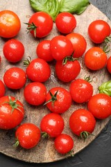 Fresh ripe tomatoes and basil on grey textured table, top view
