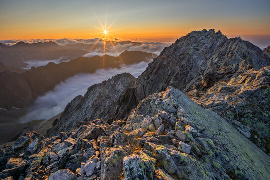 Aerial view of a majestic, sun-kissed Maly Ladovy stit peak piercing through a sea of clouds at sunrise, Tatranska Javorina, Presov Region, Slovakia.