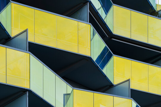 Yellow glass balcony architecture with strong geometric facade composition emphasizing minimal design and modern urban building structure captured in clean daylight perspective.