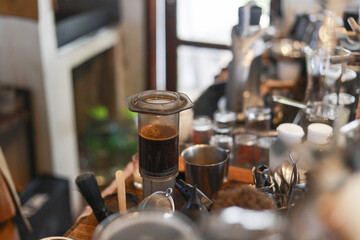 Professional barista station with coffee press brewing dark aromatic espresso. This cozy cafe environment provides warm and inviting feeling for fresh morning beverage