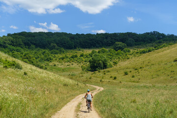 Obraz premium Woman Cycling on Dirt Road near Sighisoara, Transylvania, Romania