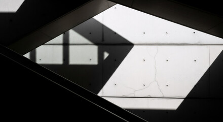 Obraz premium Modern architecture detail featuring contrasting light and shadow on concrete surfaces creates geometric patterns.