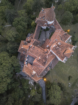Aerial view of a historic structure with terracotta tiled roofs nestled amid lush greenery, its ancient walls whispering tales of times past, Bucharest, Romania.