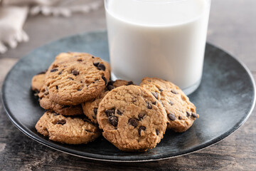 Chocolate chip cookies and milk for breakfast on rustic wooden table