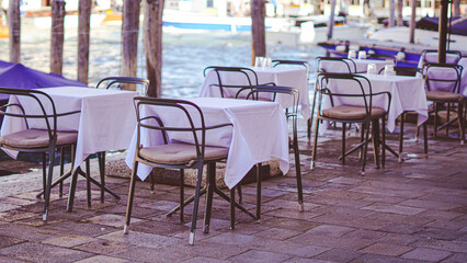 cozy outdoor cafe by venice canal with charming italian atmosphere.