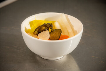 Assorted Pickled Vegetables Colourful mix of pickled cucumber, daikon, carrot, onion, and cabbage served in a white bowl, showcasing a tangy and crunchy texture perfect as a side dish or appetizer