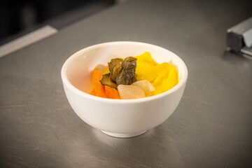 Assorted Pickled Vegetables Colourful mix of pickled cucumber, daikon, carrot, onion, and cabbage served in a white bowl, showcasing a tangy and crunchy texture perfect as a side dish or appetizer