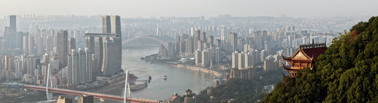 Aerial view of Chongqing's skyline shimmers in the sunset, bridges arch gracefully over the river, and a traditional pagoda nestles amidst lush greenery, Chongqing, China.