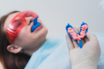 Naklejka premium doctor orthodontist performs a procedure for cleaning teeth