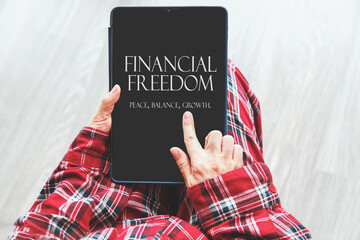 woman in red plaid pajamas holding tablet with text Financial Freedom Peace, Balance, Growth on...