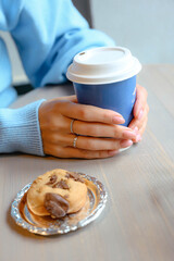 Girl holding blue coffee in her hands