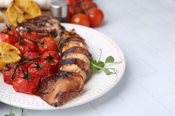 Tasty stuffed squid, microgreens, lemon and tomatoes on white tiled table, closeup. Space for text