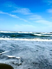 Fototapeta premium Ocean waves with foam and blue sky