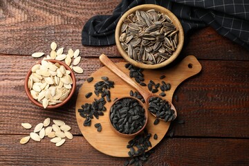 Different seeds on wooden table, flat lay