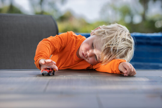 Tired little boy playing with a toy